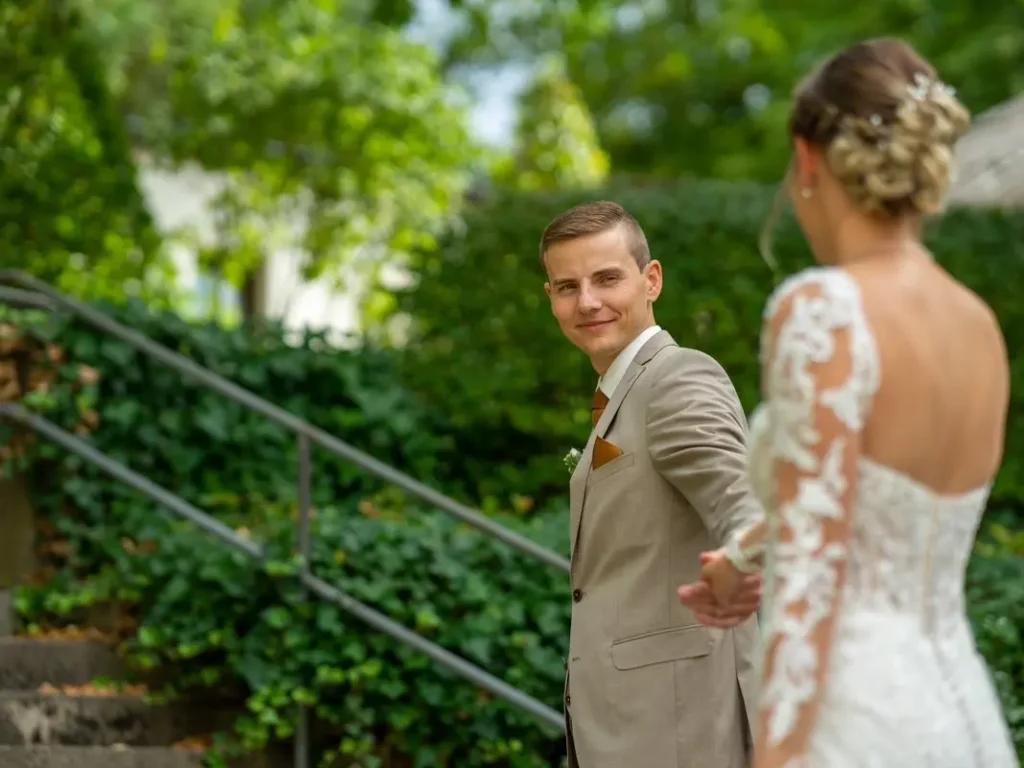 Bräutigam dreht sich zur Braut um und hält diese an der Hand fest. Fotografiert von hochzeitsfotograf-bamberg.net