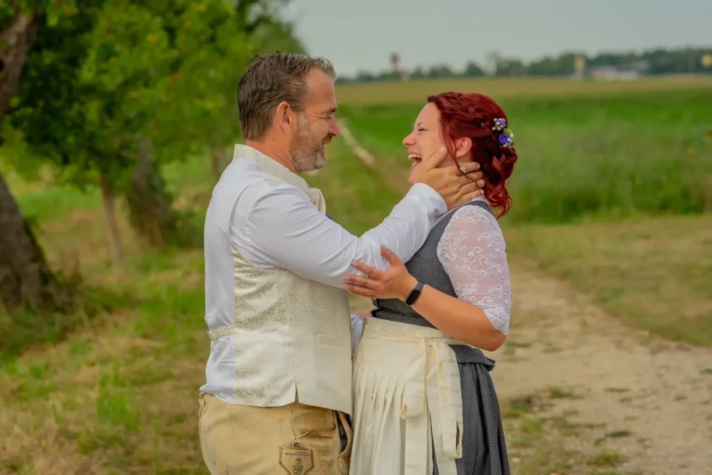 Brautpaar in Trachtenmode gekleidet. Brautpaar schaut sich an, nachdem sich der Bräutigam beim First Look umgedreht hat. Fotografiert von hochzeitsfotograf-bamberg.net